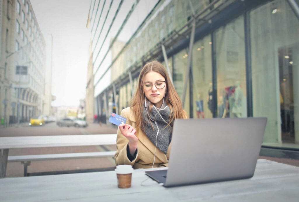 Business owner holding a credit card in front of a laptop