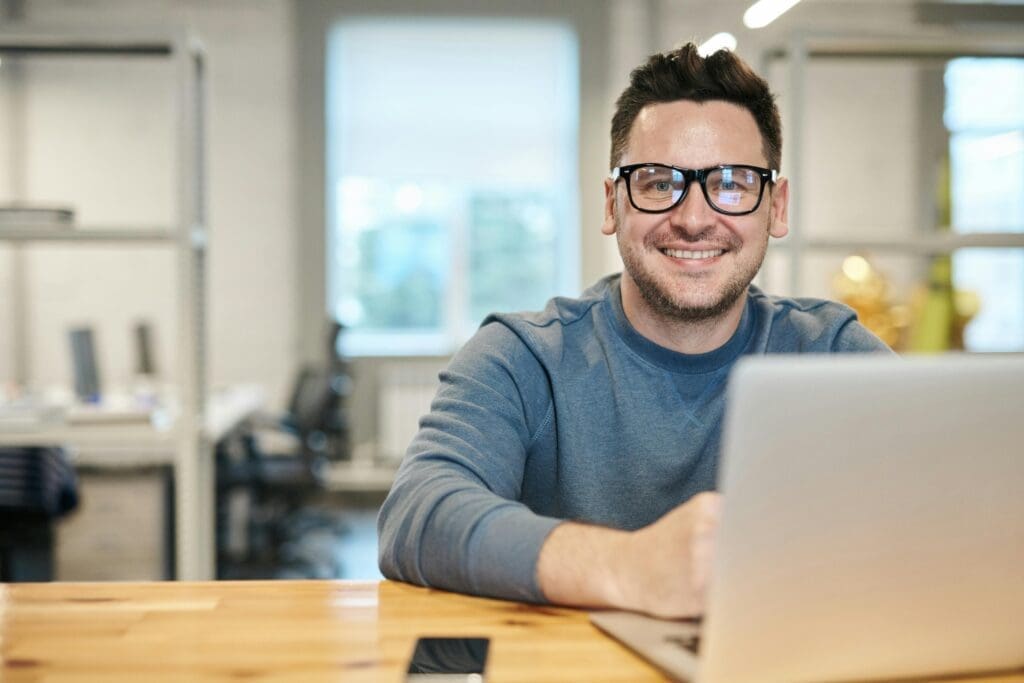 Businessman smiling while in front of a laptop